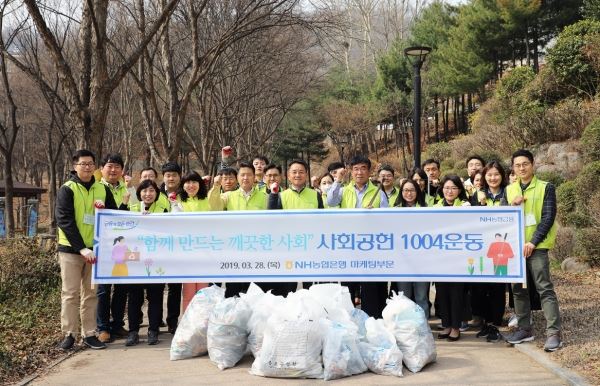 (사진: 김인태 부행장(가운데)과 김홍범 마케팅전략부장(왼쪽), 최정훈 개인고객부장(오른쪽), 마케팅부문 임직원으로 구성된 1004봉사단이 서대문독립공원 일대를 찾아 환경정화를 실시했다.)